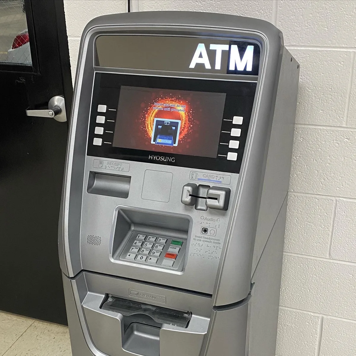 Close view of a Hyosung ATM fascia showing the screen, card reader and keypad